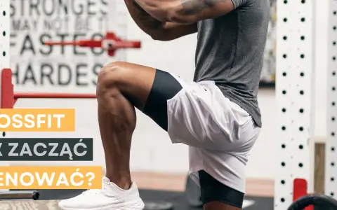 Mężczyzna w stroju sportowym wykonuje ćwiczenie w siłowni CrossFit.