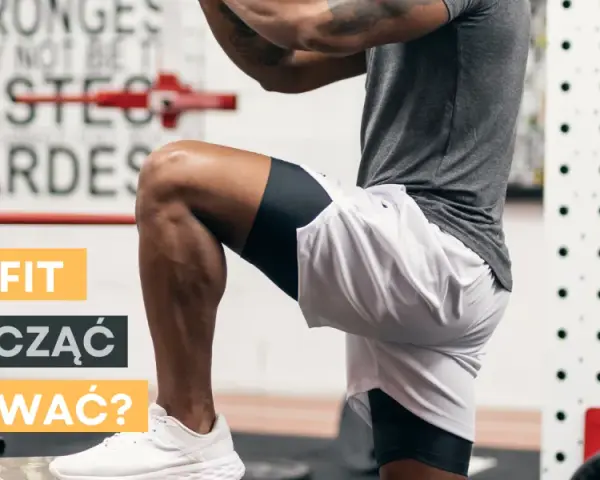 Mężczyzna w stroju sportowym wykonuje ćwiczenie w siłowni CrossFit.