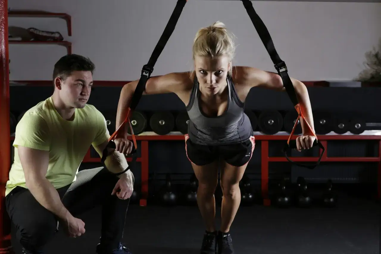 osoba wykonująca ćwiczenia CrossFit z trenerem